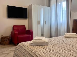 a bedroom with two beds and a red chair and a television at Villa Colle dei Trulli Monopoli in Monopoli +17 photos