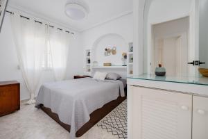 biała sypialnia z łóżkiem i blatem w obiekcie CB Living - Cozy condo with patio, Playa Flamenca w mieście Orihuela Costa