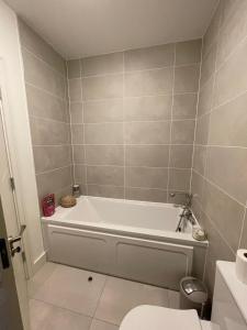 a bathroom with a white tub and a toilet at Cozy Room in Dublin
