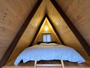 a bed in a triangular room in a wooden house at Riverside Jahliye, Chouf in Al Jāhilīyah +46 photos