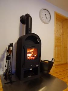 einen Herd in einem Raum mit einer Uhr an der Wand in der Unterkunft Ferienwohnungen im Kreuztal in Neuwerk