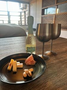 a plate of food on a table next to a wine glass at 真鶴海の見える古民家風ジャパニーズルームapartment Hotel途乃中W2 in Manazuru