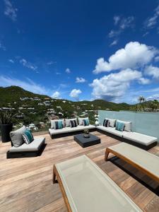 a patio with couches sitting on a wooden deck at Villa Leo St jean St Barthelemy in Saint Barthelemy
