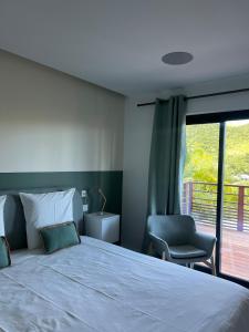 a bedroom with a bed and a chair and a window at Villa Leo St jean St Barthelemy in Saint Barthelemy +48 photos
