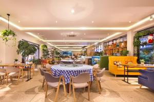 Hotel Del Moon في يانغتشو: مطعم مع طاولة وكراسي في غرفة