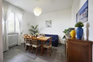 a dining room with a table and a blue couch at [LIDO DI FERMO-FREE PARKING] Appartamento miramare in Lido di Fermo