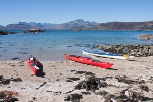 trois bateaux assis sur une plage près de l'eau dans l'établissement The Hirsel on Skye, à Ord 9 autres photos
