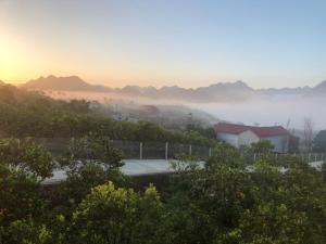 a misty view of a city with mountains in the background at Nhà gỗ Mộc châu Panorama in Mộc Châu
