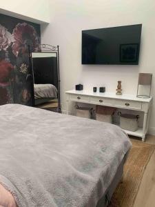 a bedroom with a bed and a desk with a television at Designer loft with terrace in Neuss