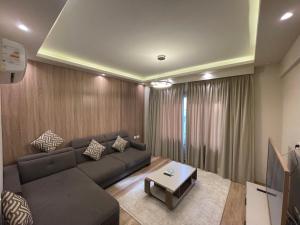 ein Wohnzimmer mit Sofa und Tisch in der Unterkunft Love apartment in New cairo