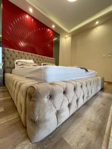 ein großes Bett in einem Schlafzimmer mit einer roten Wand in der Unterkunft Love apartment in New cairo + 76 Fotos