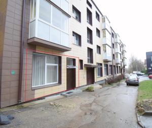 an apartment building with a car parked next to it at Vilniaus 99 Apartamentai in Šiauliai
