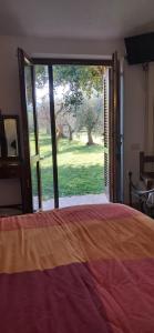 a bedroom with a bed and a large sliding glass door at Villetta 3 km dal mare in Castagneto Carducci