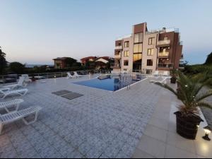 a patio with a swimming pool next to a building at Afrodita Apartments 2 in Sinemorets
