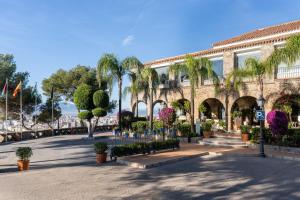 un edificio con palmeras y plantas en un patio en Parador de Málaga Gibralfaro, en Málaga