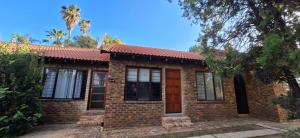 a brick house with a red roof at Jukskei Big5 - Rhino in Fourways