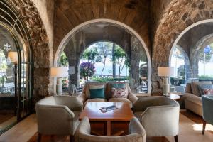 sala de estar con arcos, mesa y sillas en Parador de Málaga Gibralfaro, en Málaga