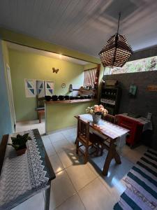ein Wohnzimmer mit Tisch und Küche in der Unterkunft casa temporada pedra azul in Domingos Martins