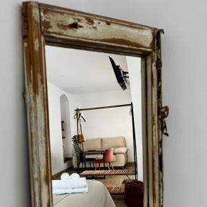 a mirror reflecting a living room with a couch at CasaElbarranko in Arcos de la Frontera