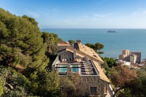 una casa en una colina con el océano en el fondo en Parador de Málaga Gibralfaro, en Málaga