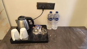 a tea kettle and two bottles of water on a table at Hotel The Pine Villa in Mussoorie