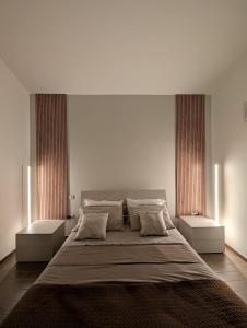 a bedroom with a large bed with two windows at Casa Tartaruga in SantʼAntìoco