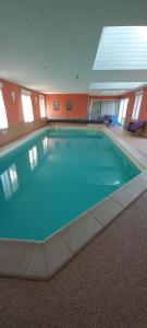 a large swimming pool in a large building at Le chant des oiseaux in Pouant