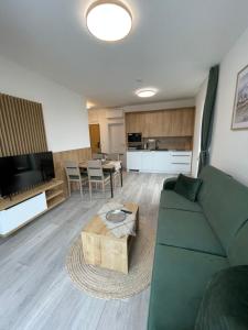 a living room with a green couch and a table at Apartmán Bešeň 408 in Bešeňová