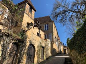 a large stone building with stairs leading down a street at Loft Montaigne Cité médiévale Sarlat in Sarlat-la-Canéda