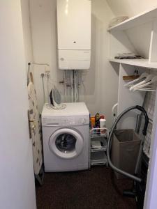 a laundry room with a washing machine and a cabinet at Loft Montaigne Cité médiévale Sarlat in Sarlat-la-Canéda