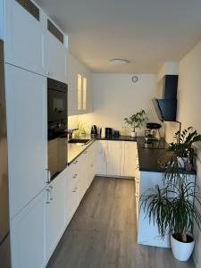 a kitchen with white cabinets and black appliances at Trondheim in Trondheim
