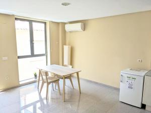 a dining room with a table and a refrigerator at Apartamentos la Creu in Bañeres de Mariola