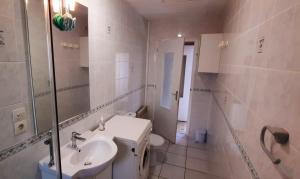 a white bathroom with a sink and a toilet at Maison de pêcheur in Brem-Sur-Mer +9 photos