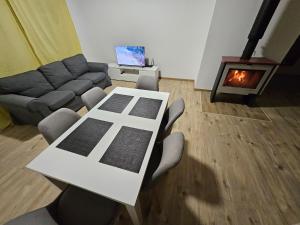 a living room with a table and chairs and a fireplace at Nové bývanie blízko Piešťan a Nového Mesta nad Váhom pre 6 osôb in Očkov