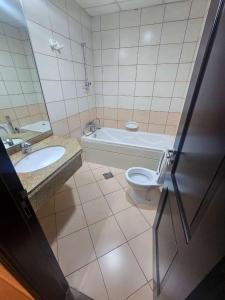 a bathroom with a tub and a toilet and a sink at Tabs Dubai Hostel in Dubai +17 photos