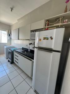 eine Küche mit einem weißen Kühlschrank und einer Spüle in der Unterkunft Encanto Parangaba in Fortaleza