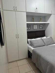 a small bedroom with a bed and white cabinets at Encanto Parangaba in Fortaleza +30 photos
