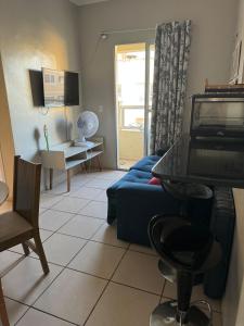 ein Wohnzimmer mit einem blauen Sofa und einem Tisch in der Unterkunft Encanto Parangaba in Fortaleza