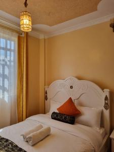 a bedroom with a white bed with a pillow and a chandelier at D & C Homes in Eldoret