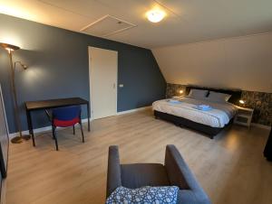 a bedroom with a bed and a table and a couch at Vrijstaande Landelijke Woning in Slagharen