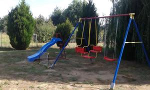 an empty playground with swings in a yard at Gyöngy-ház Balaton, önálló nyaraló in Szőlősgyörök