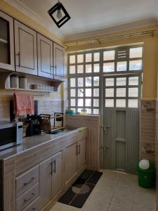 a kitchen with wooden cabinets and a microwave at D & C Homes in Eldoret