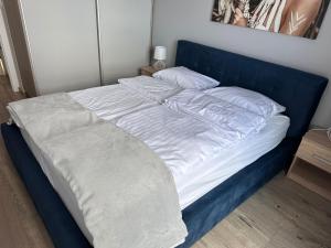 a large bed with a blue headboard and white sheets at Red Kot Lisia 12 in Zielona Góra