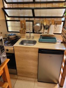 a kitchen with a sink and a stove at La casita del colibri in Córdoba +12 photos