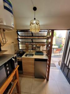 a kitchen with a sink and a stove at La casita del colibri in Córdoba