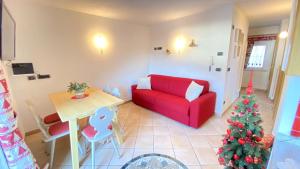 a living room with a red couch and a christmas tree at Ciasa Coderoppola in Moena
