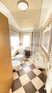 a bathroom with two toilets and two sinks at Ciasa Coderoppola in Moena +10 photos