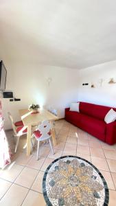 a living room with a red couch and a table at Ciasa Coderoppola in Moena
