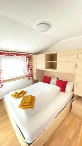 a bedroom with a large white bed with red pillows at Ciasa Coderoppola in Moena
