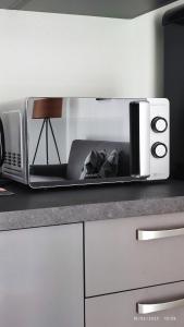 un four micro-ondes installé au-dessus d'un comptoir de cuisine dans l'établissement Appartamento AL 45 B.go Roma -Vr- con garage, à Vérone